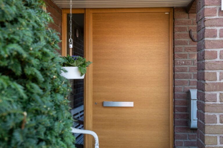 Eingangsbereich eines Hauses mit moderner Holztür,